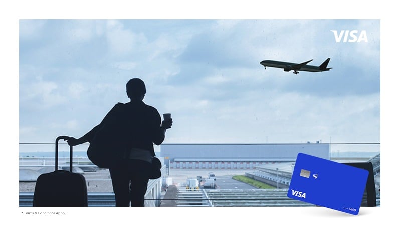 A woman with a suitcase in the airport and a Visa card on the foreground