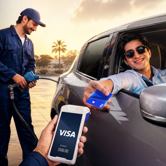 Driver in sunglasses pays with a Visa card at a gas station while an attendant refuels the car